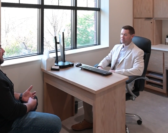 practitioner sitting at desk and patient in chair