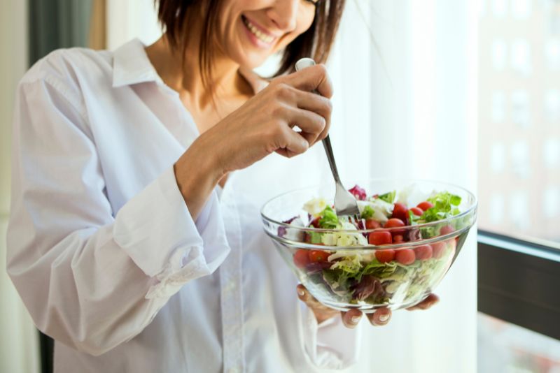 smiling woman eating a salad