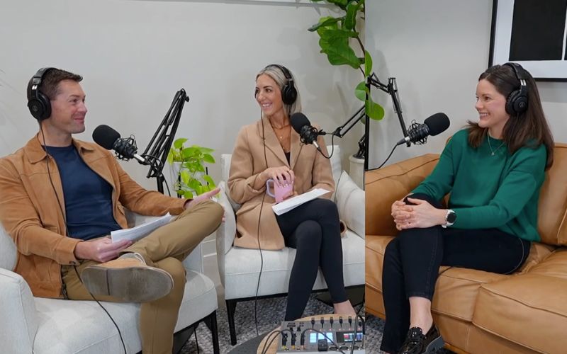 three people with headsets sitting on a couch in a talk show format